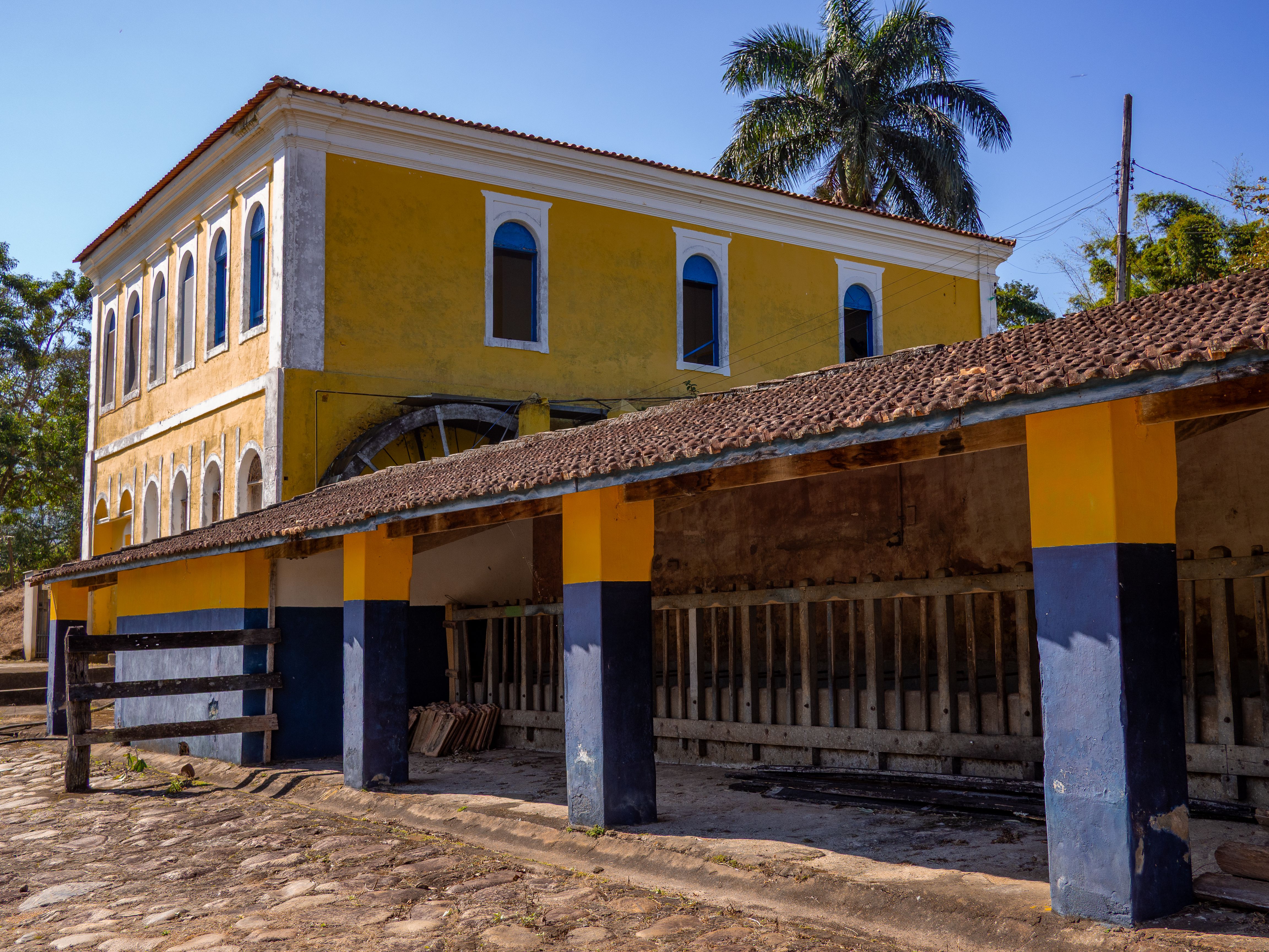 A vibrant yellow colonial building in a rural setting in Brazil, representing historic architecture.