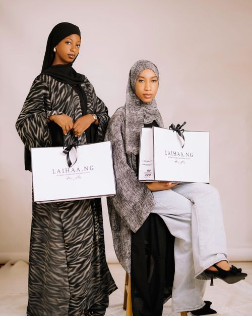 Free Two women showcasing elegant modest fashion with shopping bags in Nigeria. Stock Photo