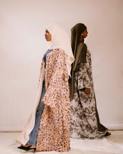 Free Two women in stylish abayas showcasing modern modest fashion indoors. Stock Photo