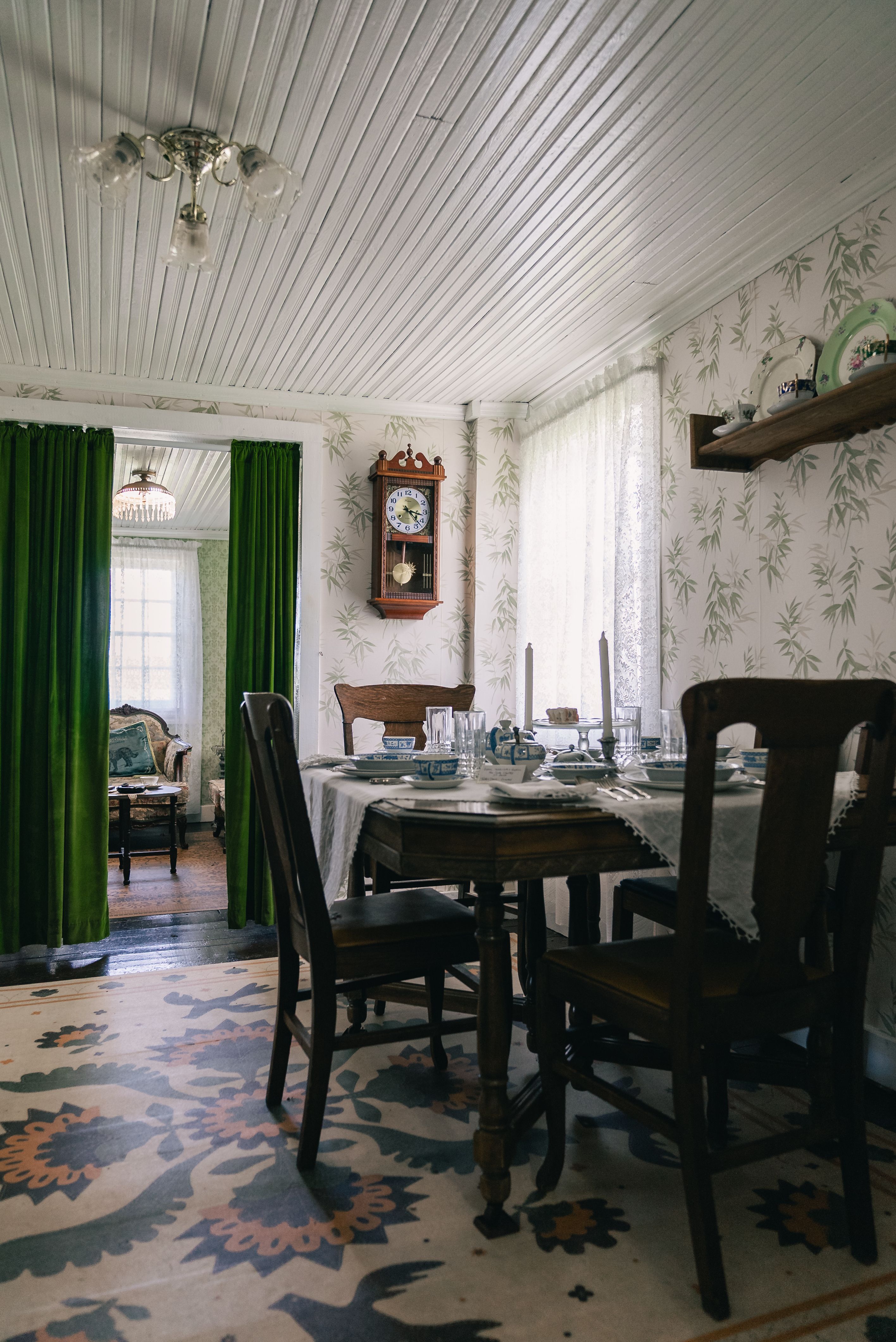 Fotomural Acogedor comedor de estilo vintage con muebles antiguos, una mesa puesta de forma clásica y un elegante papel pintado.