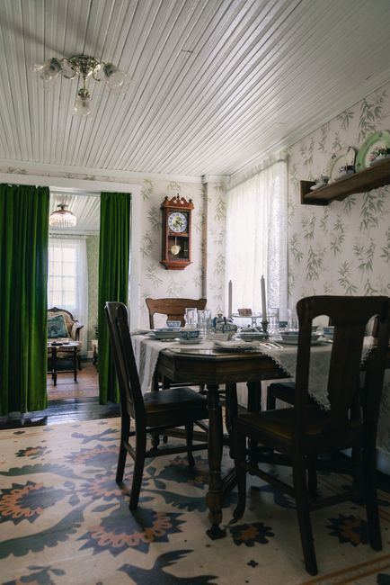 Fotomural Acogedor comedor de estilo vintage con muebles antiguos, una mesa puesta de forma clásica y un elegante papel pintado.
