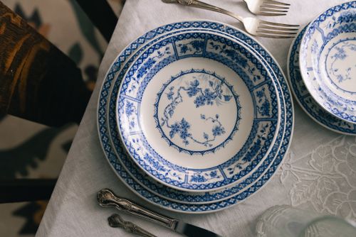 Free A classic dining setup featuring blue floral-patterned china on a white tablecloth, ready for a meal. Stock Photo
