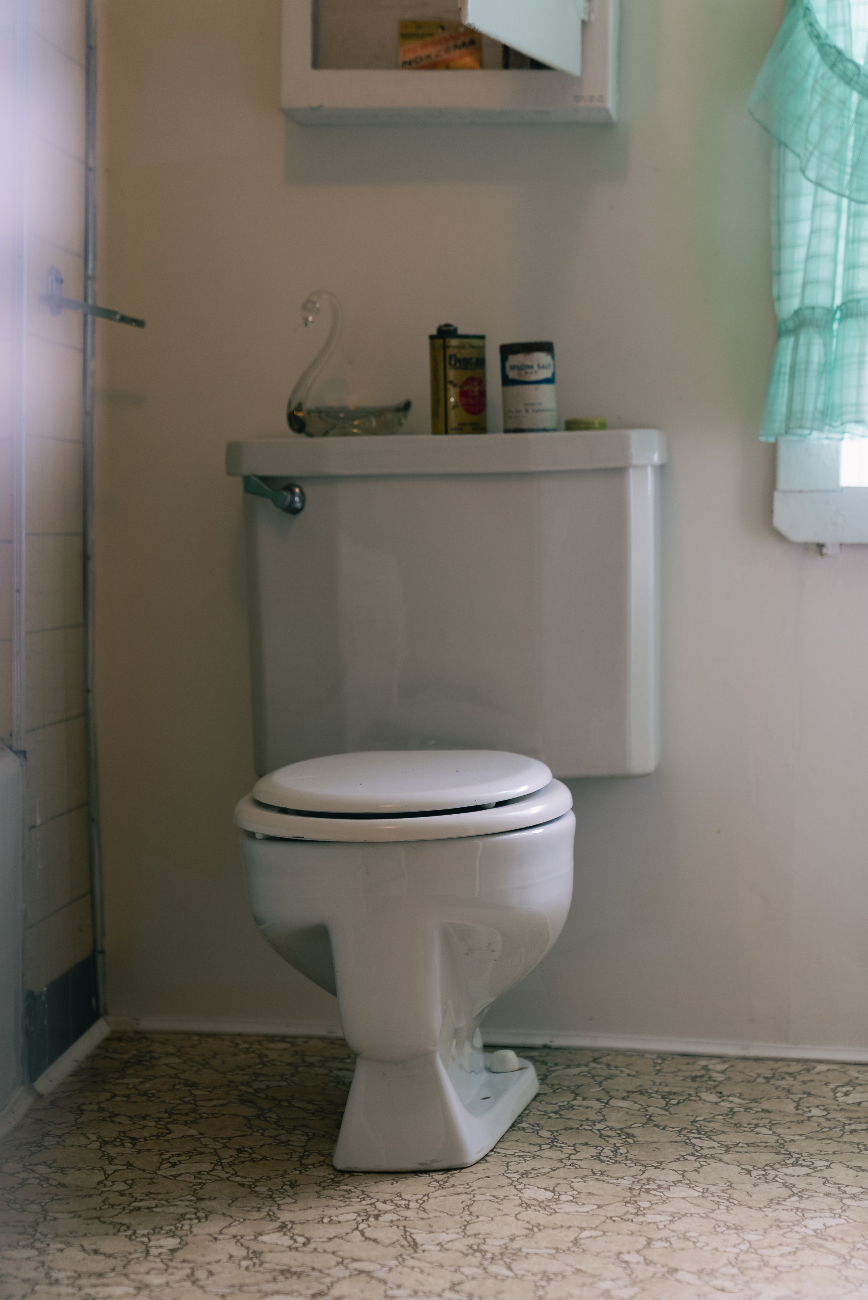 A simple bathroom interior with a white toilet in soft light.