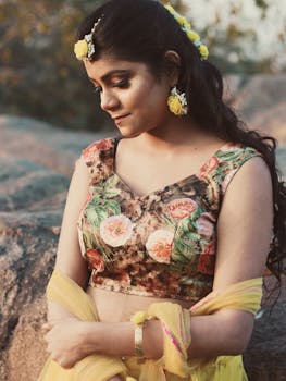 一位身着花卉连衣裙的南亚女性在户外显得宁静优雅，美丽动人