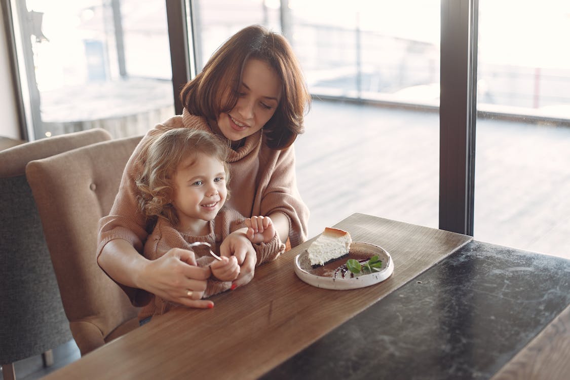 Mother and daughter having dessert in cozy cafe