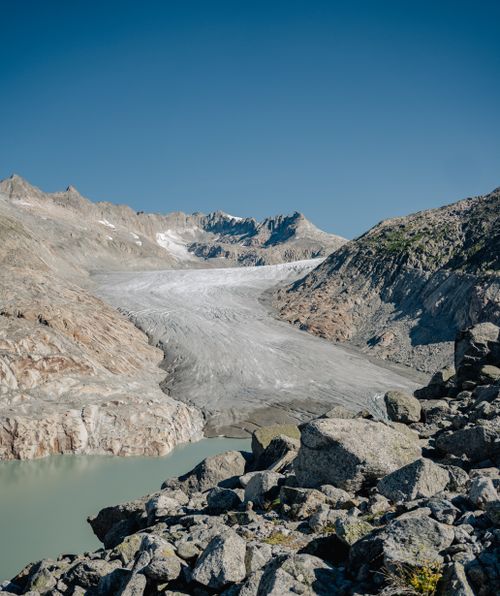 Free Breathtaking photo of Aletsch Glacier surrounded by rugged mountains under a clear blue sky. Stock Photo