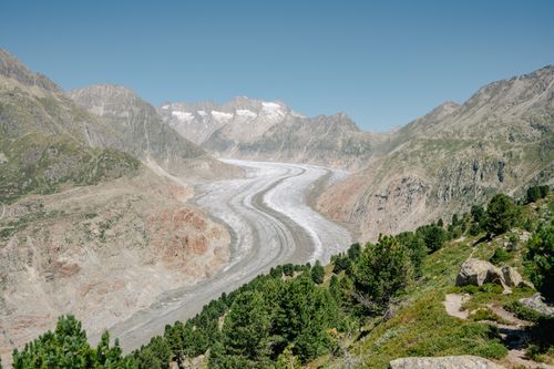 Free Expansive view of the Aletsch Glacier, the largest glacier in the Alps, surrounded by rugged mountain terrain. Stock Photo