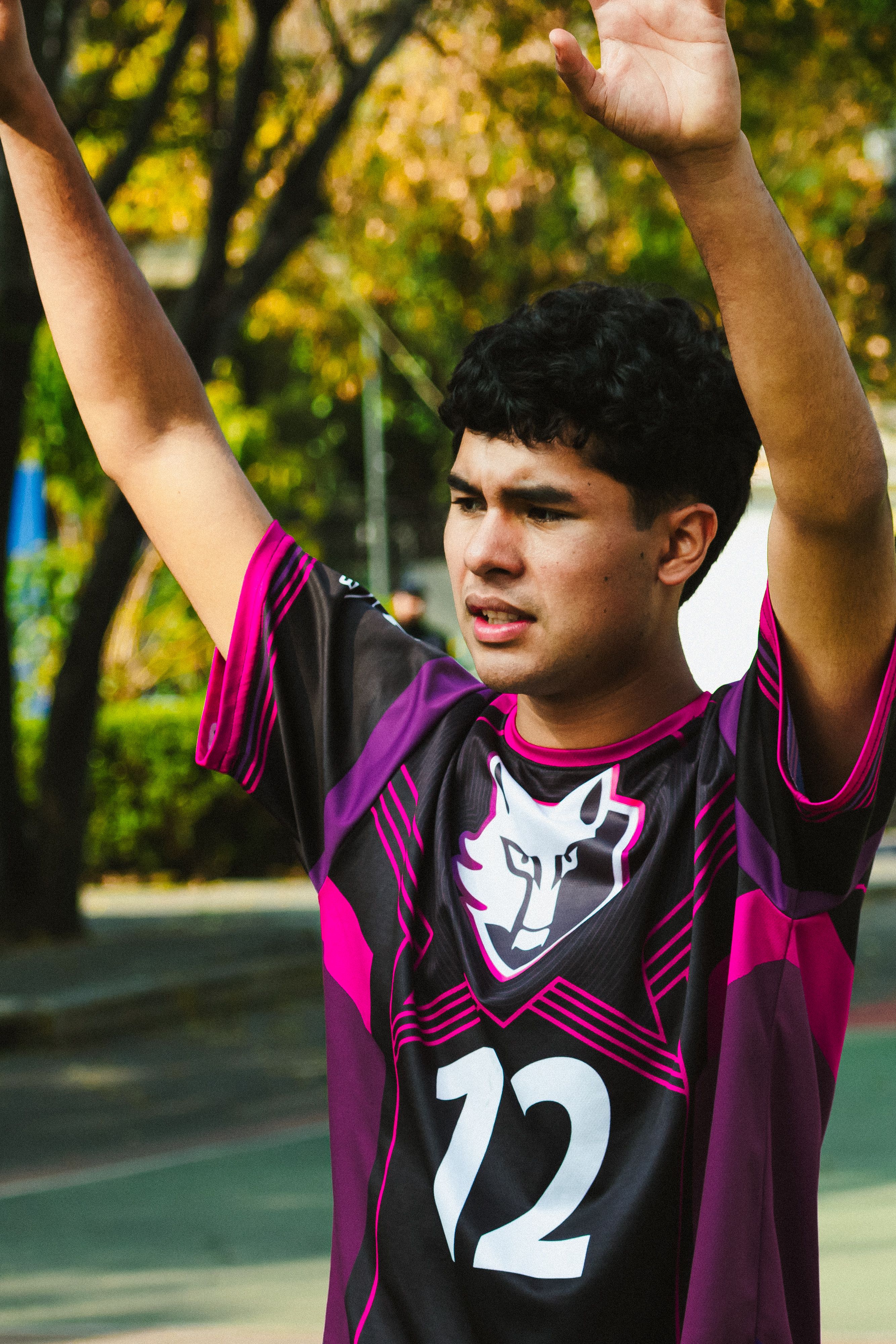 A young male volleyball player raises his arms during practice outdoors in Ciudad de México.
