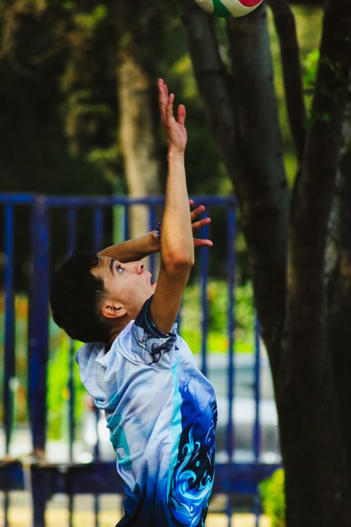 Free Teen volleyball player serves the ball outdoors during a match in Mexico City. Stock Photo