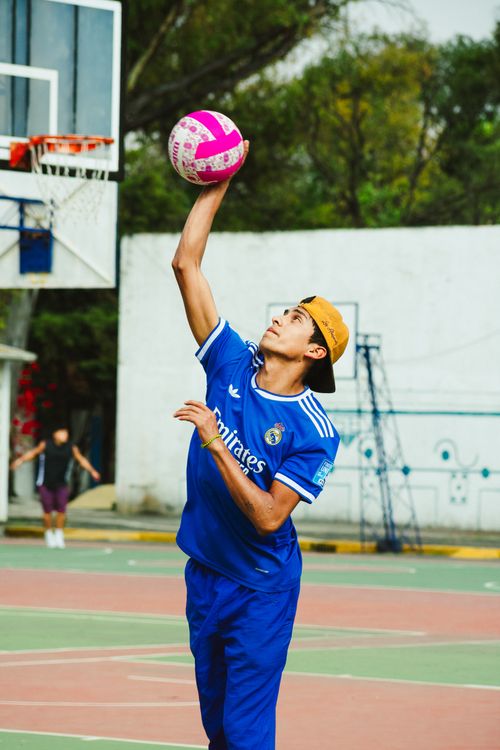 Free A young man in sportswear skillfully hits a volleyball on an outdoor court in Mexico City. Stock Photo