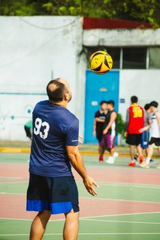 Dynamic volleyball match captured in outdoor court in Mexico City, featuring players in action.