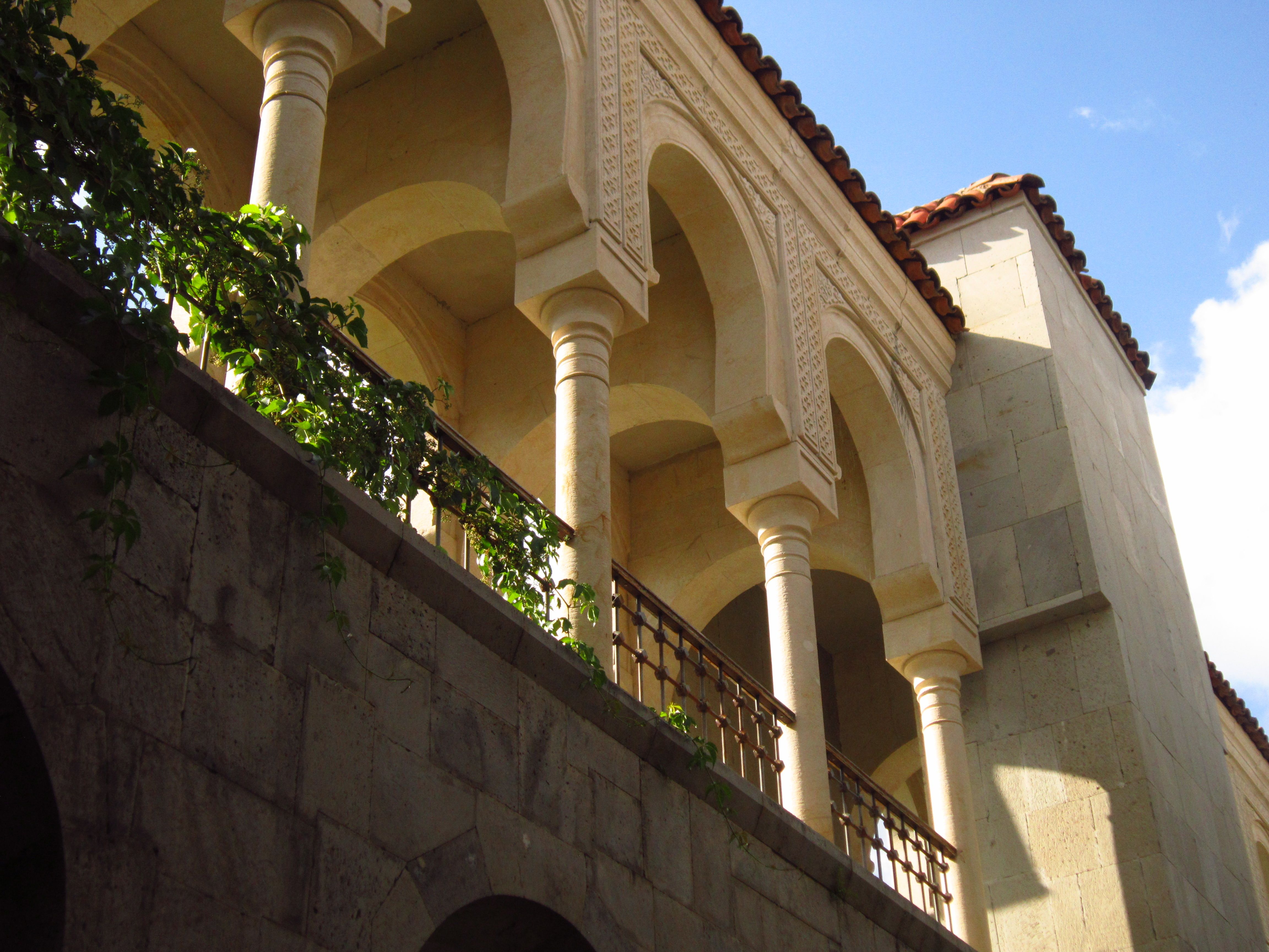 Beautiful arches of a historic building in Akhaltsikhe, Georgia, under a clear blue sky.