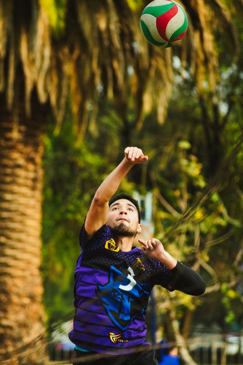Free A volleyball player jumps to hit the ball during an outdoor match, displaying athletic skill and focus. Stock Photo