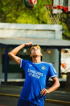 Young man in blue jersey playing volleyball outdoors on a sunny day in Mexico City.