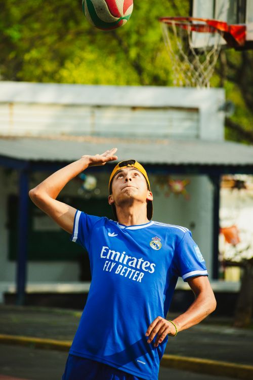 Free Young man in blue jersey playing volleyball outdoors on a sunny day in Mexico City. Stock Photo