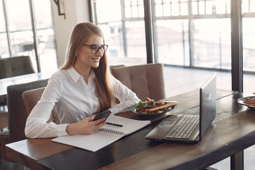 Woman in White Blazer Sitting at the Table