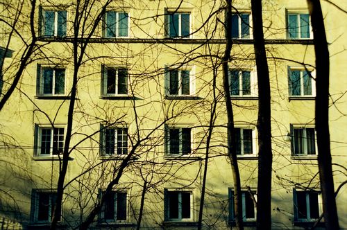 Free Facade of a yellow building with bare trees in front, capturing a suburban scene in Lviv, Ukraine. Stock Photo