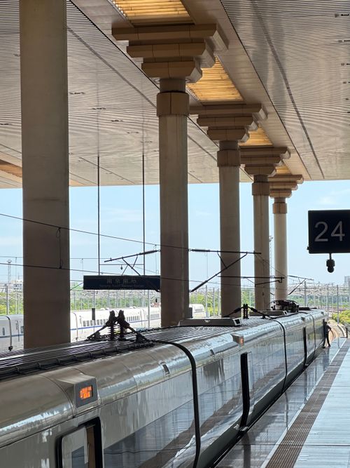 Free High-speed train at a modern station platform with sleek architecture and sunny weather. Stock Photo