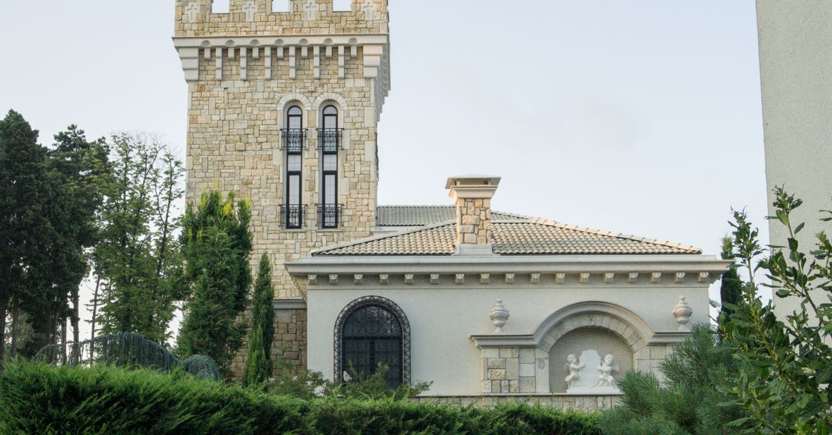 Elegant stone mansion with tower and greenery in Varna, Bulgaria.