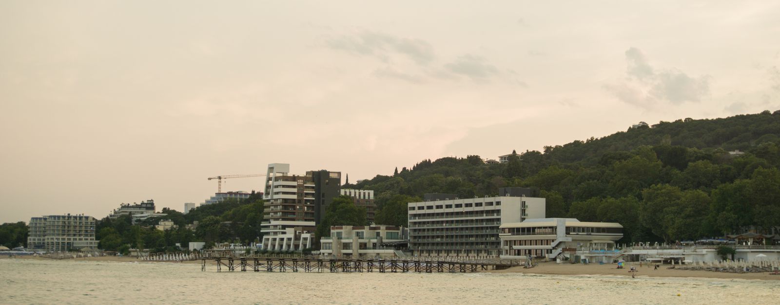 Scenic view of Varna's coastline with beachfront buildings during sunset, showcasing a tranquil summer evening.