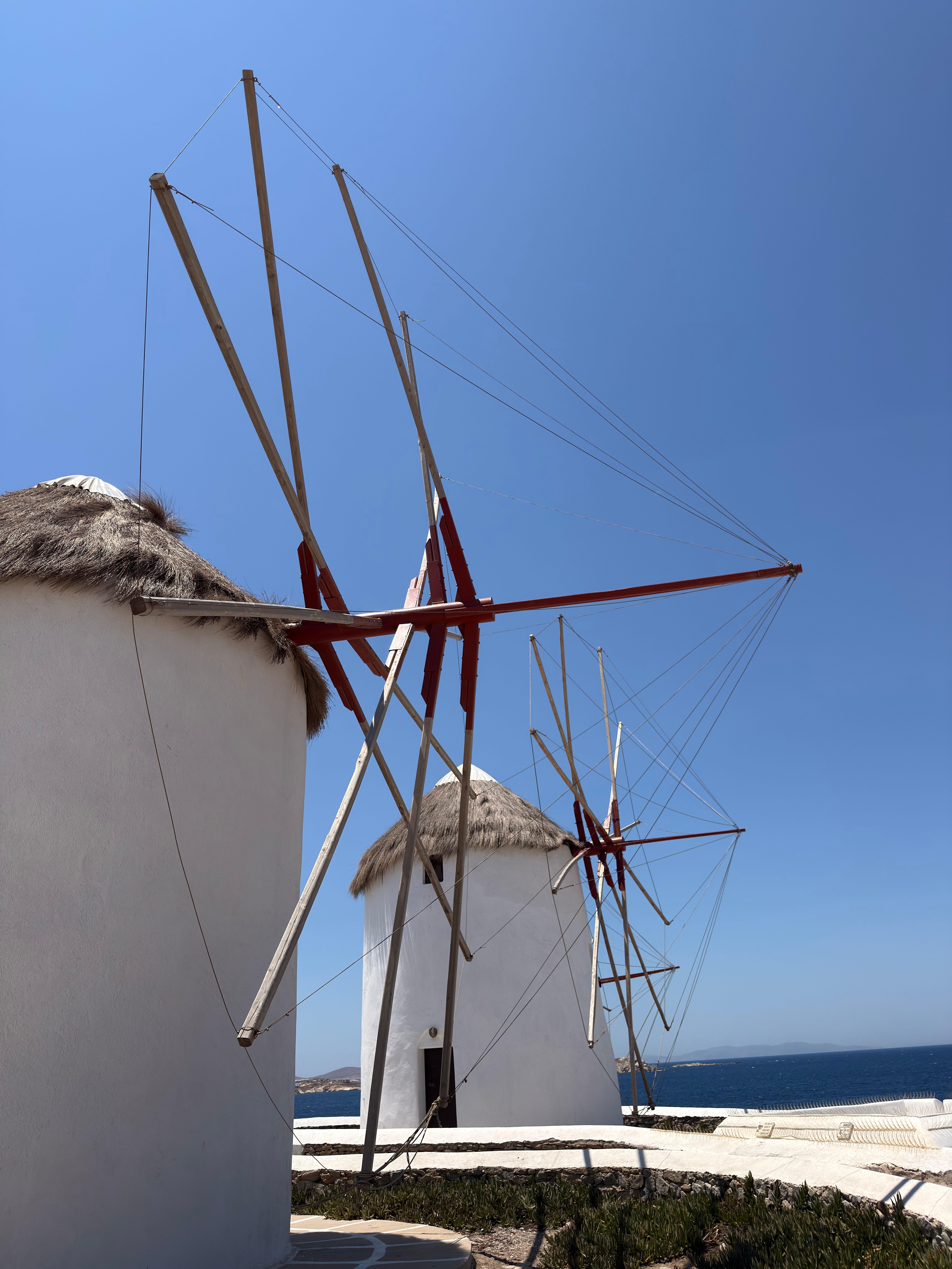 Iconic windmills of Mykonos, Greece under a clear blue sky.