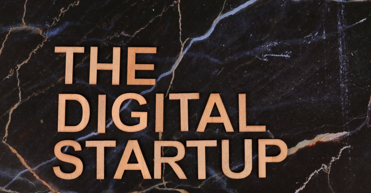Lettres en bois formant l'inscription « The Digital Startup » sur un fond en marbre foncé. Idéal pour les thèmes liés aux entreprises et à la technologie.