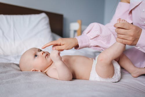 Free Crop mother playing with baby Stock Photo