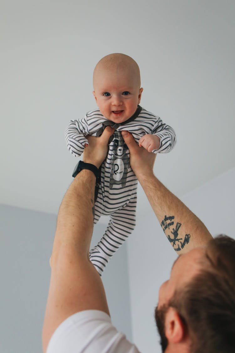  Man Carrying Baby In Black And White Stripe Onesie