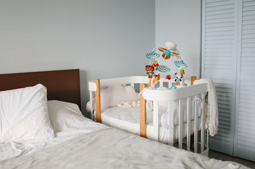 Free Crib next to bed in bedroom Stock Photo