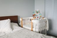 Crib next to bed in bedroom