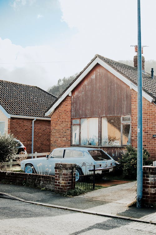 A Car Parked Beside the Brown House