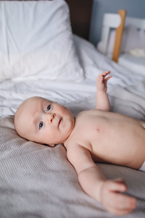 Free Baby Lying on Bed Stock Photo