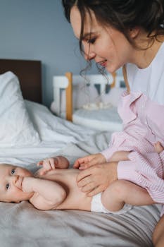 母亲在床上与婴儿亲切互动，捕捉到了温柔和联系的时刻