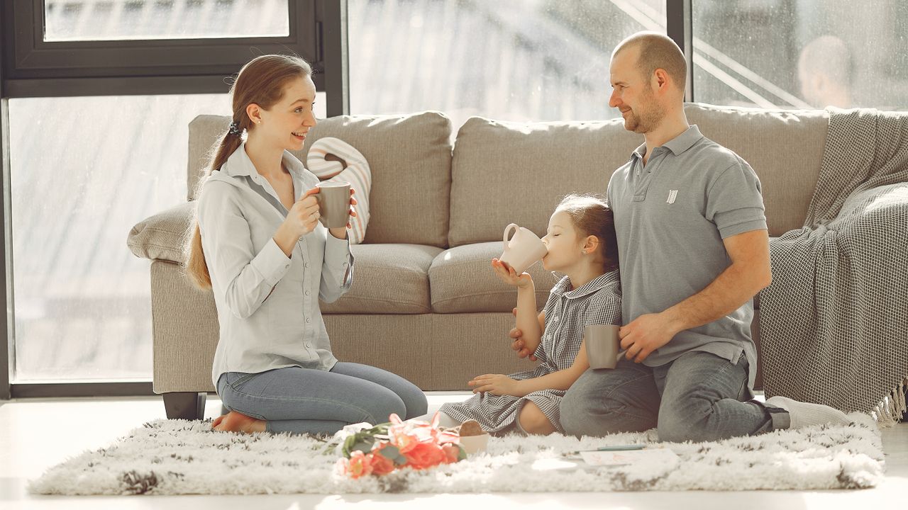 Cheerful family talking together at home over tea.
