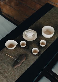 A minimalist flat lay of a traditional tea set on a woven mat, perfect for serene lifestyle visuals.