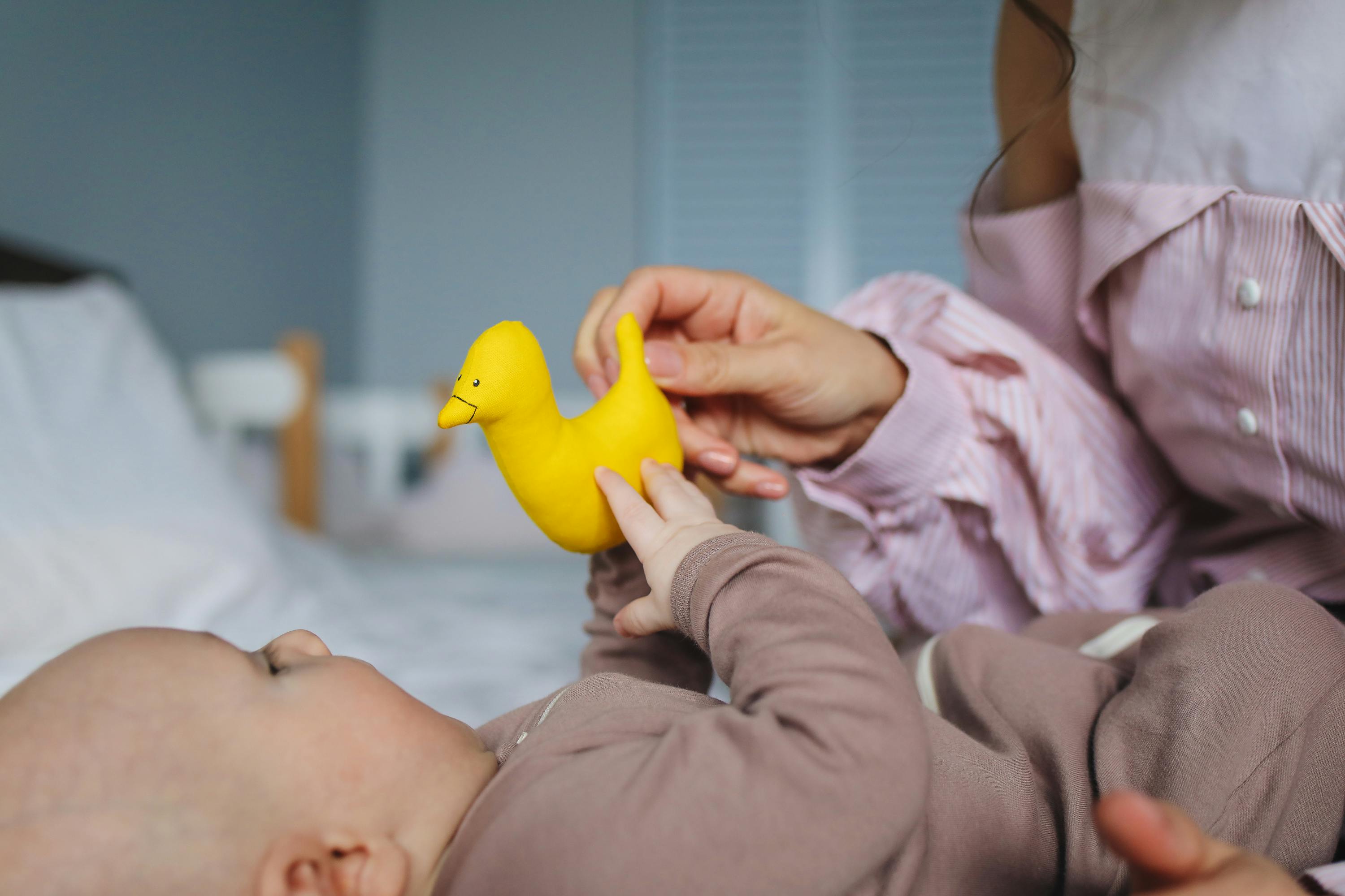 mommy playing rubber duckie with her baby