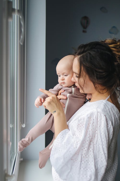 Free Mother And Child Standing By The Window Stock Photo