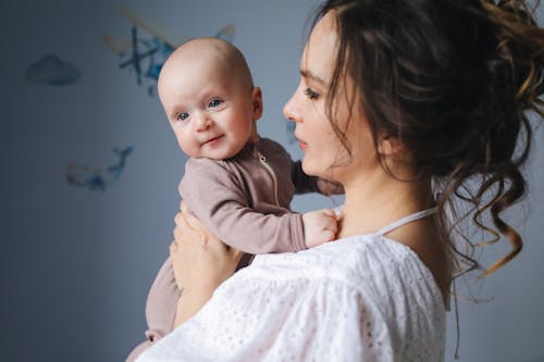 Free Close-Up Photo of Mother Carrying Her Baby Stock Photo