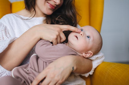  Woman in White Top Carrying Baby Wearing Brown Onesie