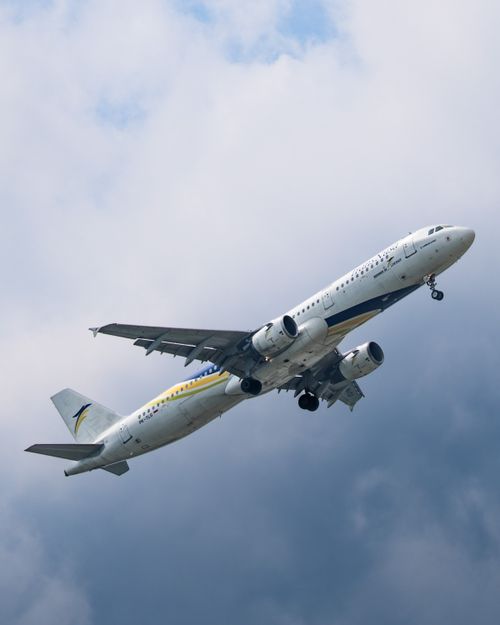 Free Airplane taking off under a cloudy sky in Sepang, Selangor, Malaysia, showcasing dynamic aviation scene. Stock Photo