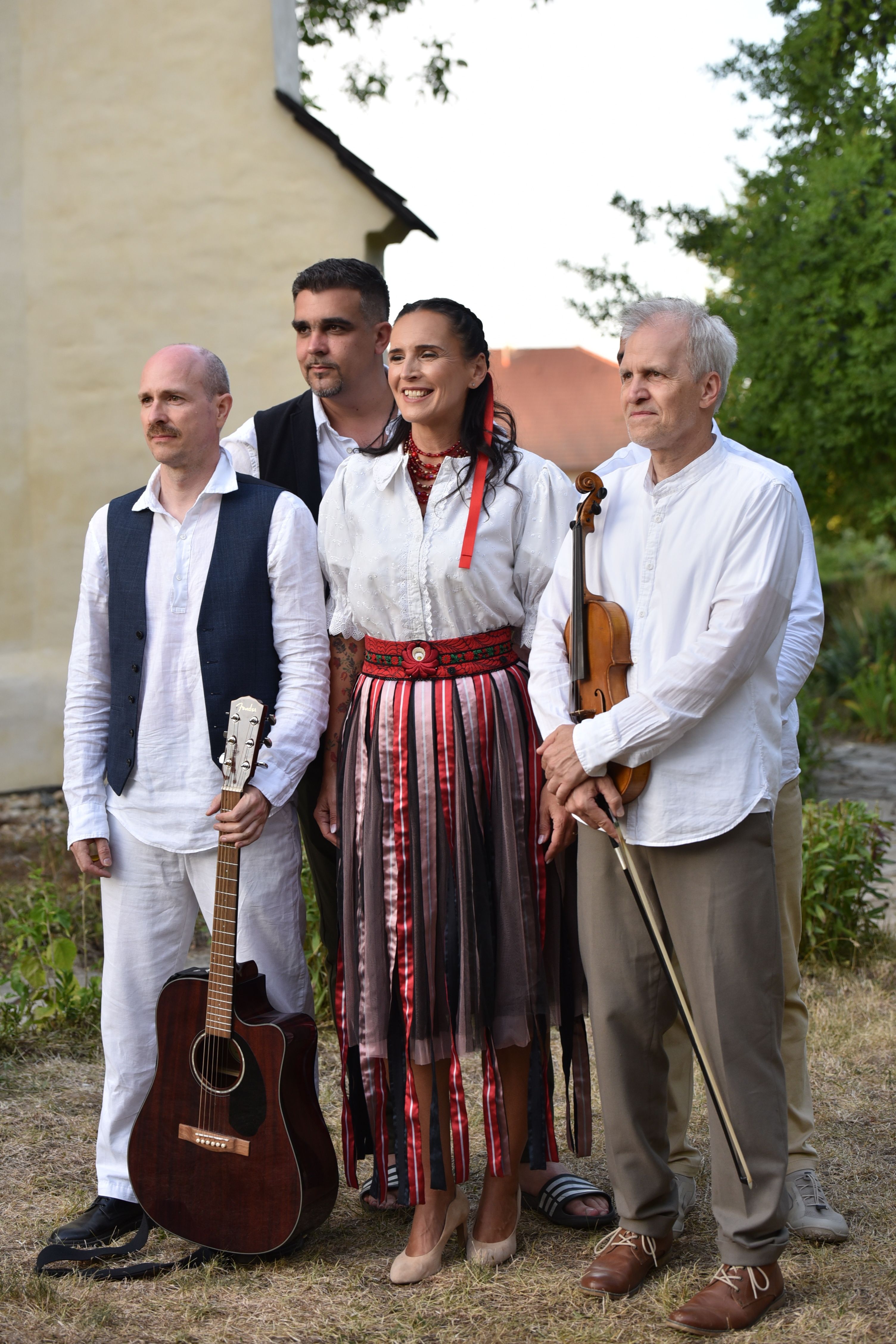 A group of musicians in traditional attire with instruments in Csaroda, Hungary.