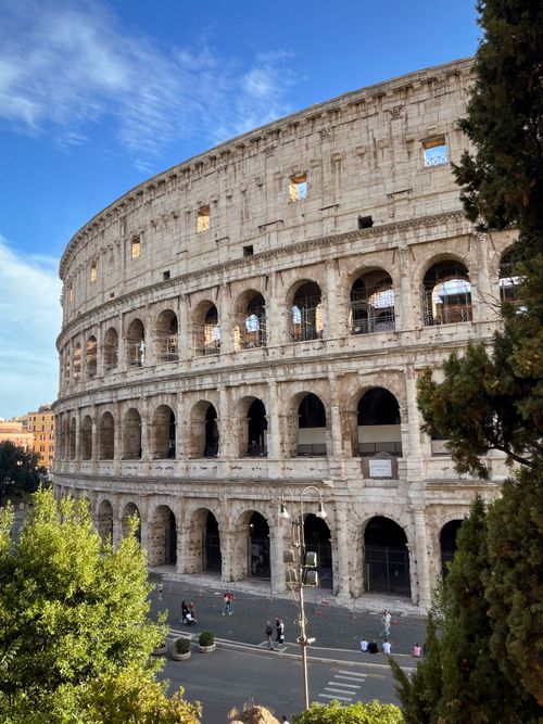 Free Beautiful day view of the historic Colosseum in Rome, capturing its ancient architecture. Stock Photo
