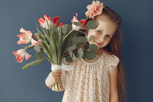 Adorable girl with flowers smiling at camera
