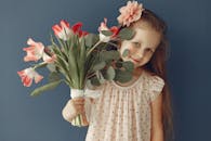 在工作室的蓝色背景前，一位迷人的女孩手持一束鲜花