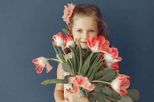 Free Girl Holding Pink and White Flowers Smiling Stock Photo