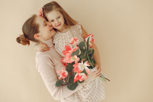A joyful moment of a mother and daughter embracing with a bouquet of tulips in hand.