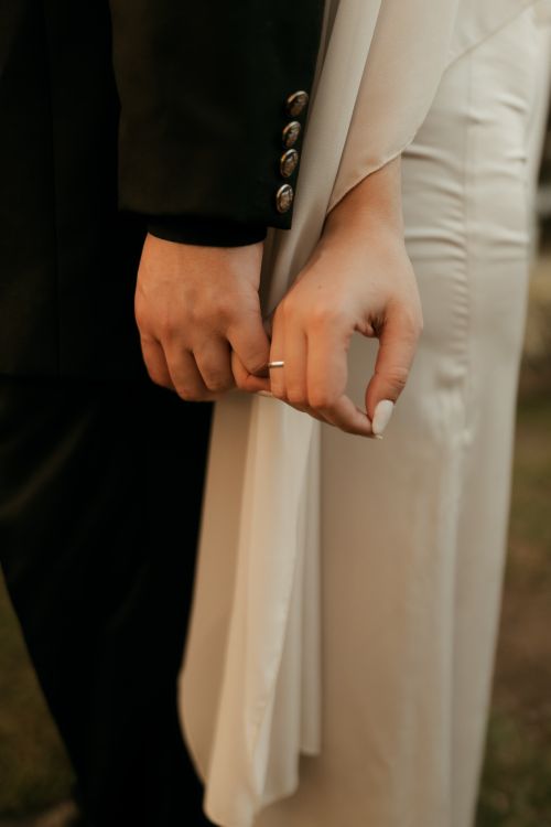 Free Close-up of a wedding couple holding hands, symbolizing love and unity. Stock Photo