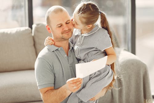 A Lovely Girl Giving Her Father A Kiss