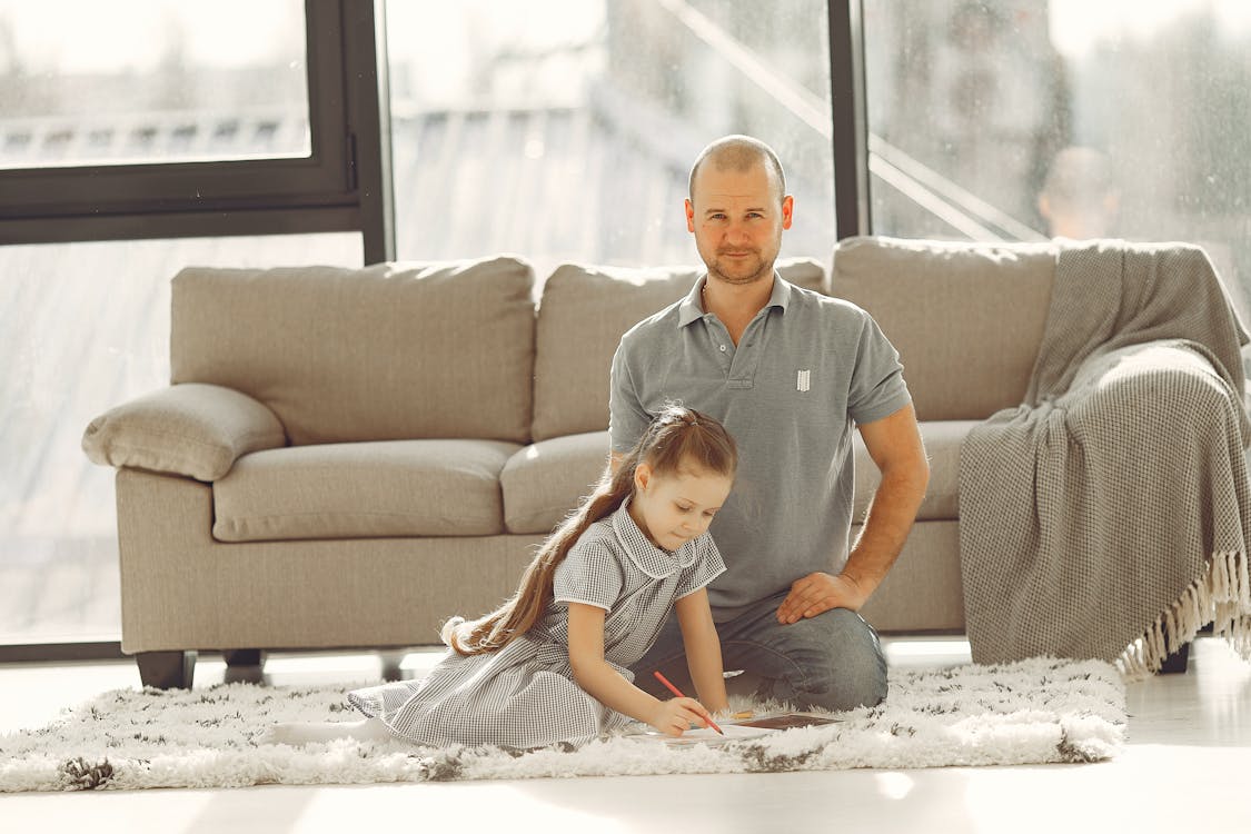 Free A Man Sitting by her Daughter on the Living Room Floor Stock Photo