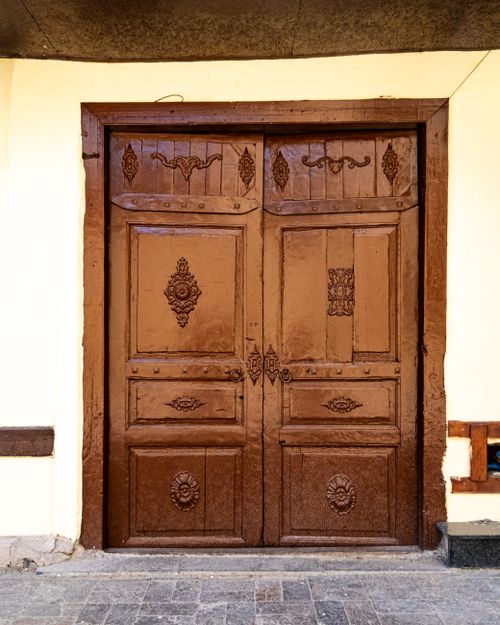 Free A detailed brown wooden door with ornate carvings in a vintage style, ideal for architecture and design themes. Stock Photo